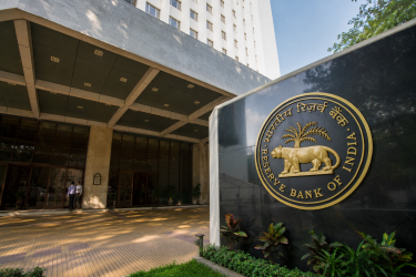 Exterior view of the Reserve Bank of India (RBI) headquarters building in Mumbai, featuring the central bank's official seal and entrance.
