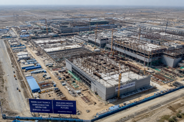 Aerial view of the massive construction site of the Tata Electronics semiconductor mega-fab facility showing cleanroom structural foundations in Dholera, Gujarat.