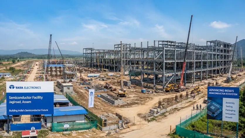 A panoramic view of the Tata Electronics semiconductor facility construction site at Jagiroad, Assam, showcasing industrial structural steel frames.