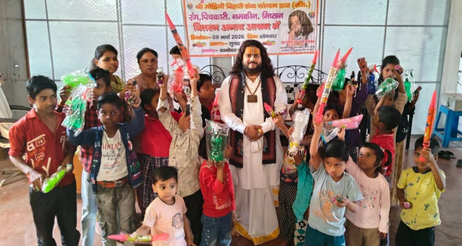अभिषेक कृष्ण शास्त्री जी महाराज अनाथ आश्रम के बच्चों को पिचकारी और मिठाई बांटते हुए।