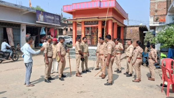 महराजगंज के खोरिया बाजार में शिव मंदिर के बाहर तैनात भारी पुलिस बल और ग्रामीणों की भीड़।