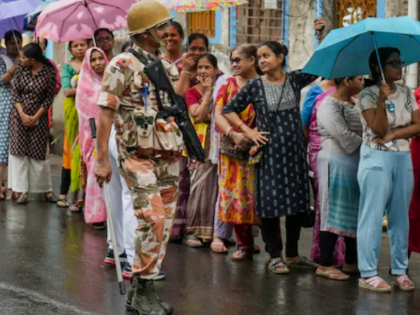 पश्चिम बंगाल चुनाव 2026 के दूसरे चरण में मतदान केंद्र के बाहर वोट देने के लिए खड़ी महिलाओं की लंबी कतार।
