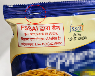FSSAI द्वारा बैन की गई खाद्य पदार्थों के पैकेट पर लगी स्टेपल पिन की तस्वीर।
