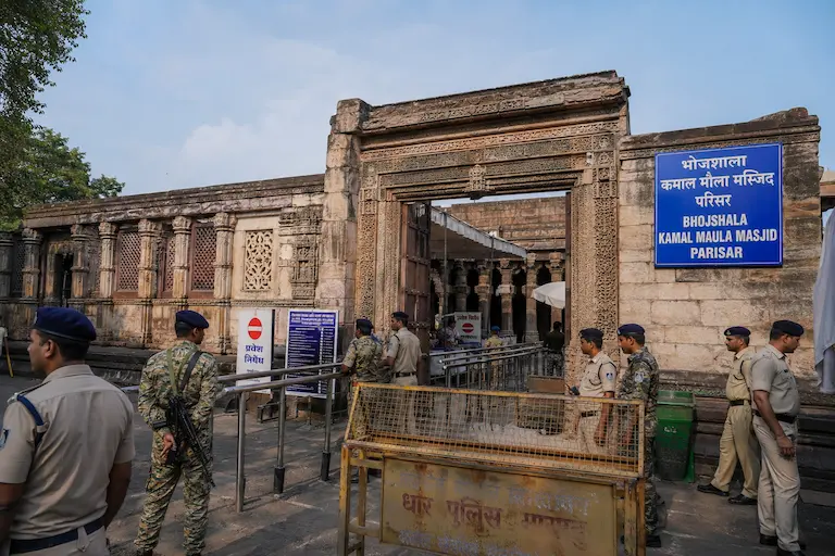 धार, मध्य प्रदेश में स्थित ऐतिहासिक भोजशाला-कमाल मौला मस्जिद परिसर के प्राचीन स्तंभों और नक्काशीदार प्रवेश द्वार का बाहरी दृश्य, जहां सुरक्षा के कड़े इंतजाम और पुलिस बल तैनात है।