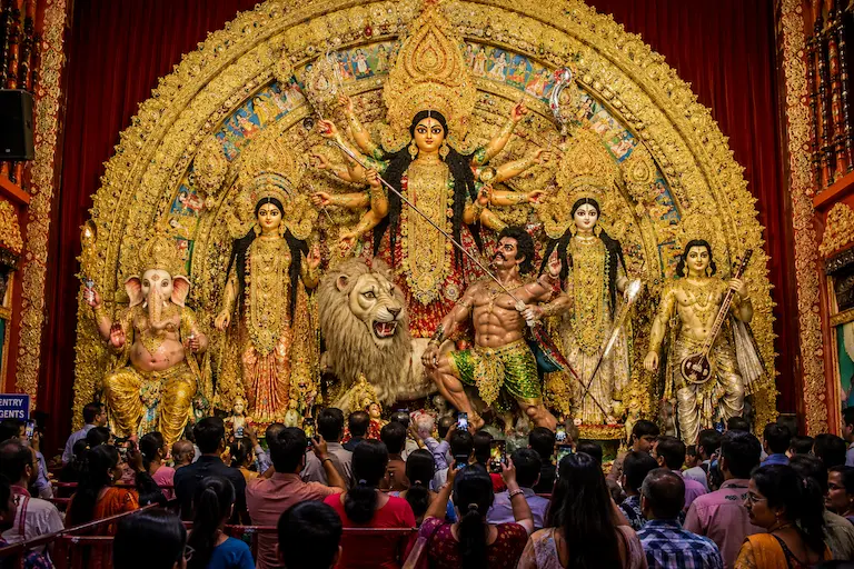 पश्चिम बंगाल में दुर्गा पूजा पंडाल के सामने देवी दुर्गा की भव्य प्रतिमा।